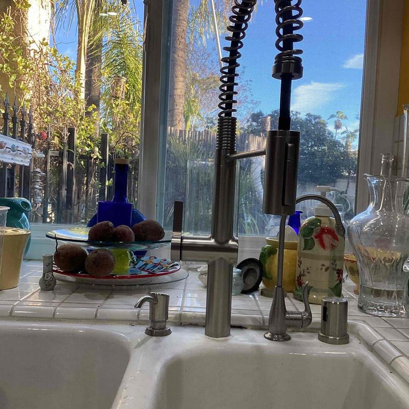 Kitchen faucet with pull-down sprayer installed on sink