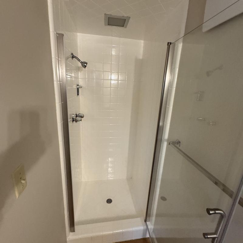 Shower stall with glass door and tiled walls