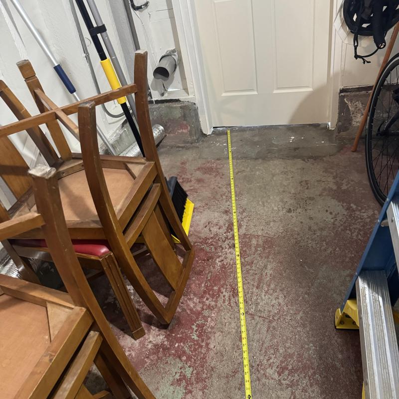 Dryer vent pipe rough-in with tape measure on floor