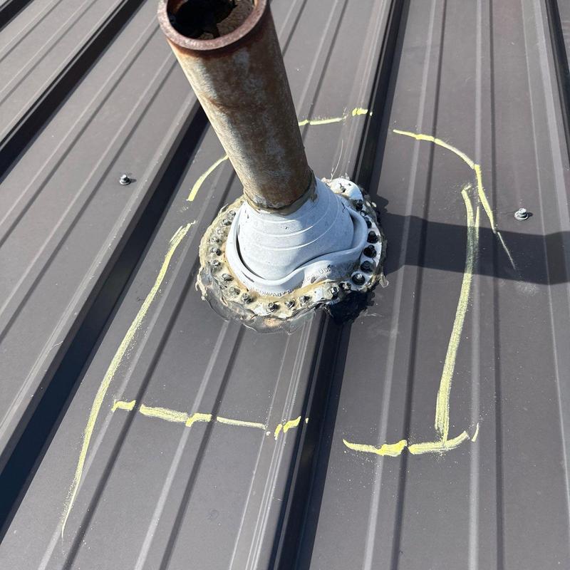 Metal roof pipe flashing with sealant and chalk marks