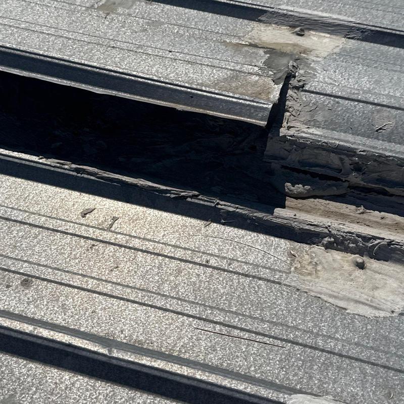 Metal roofing panel with damaged seam and sealant issues