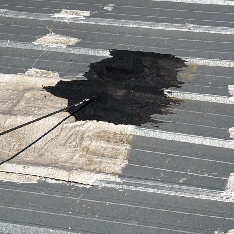 Metal roof panel with sealing compound patch