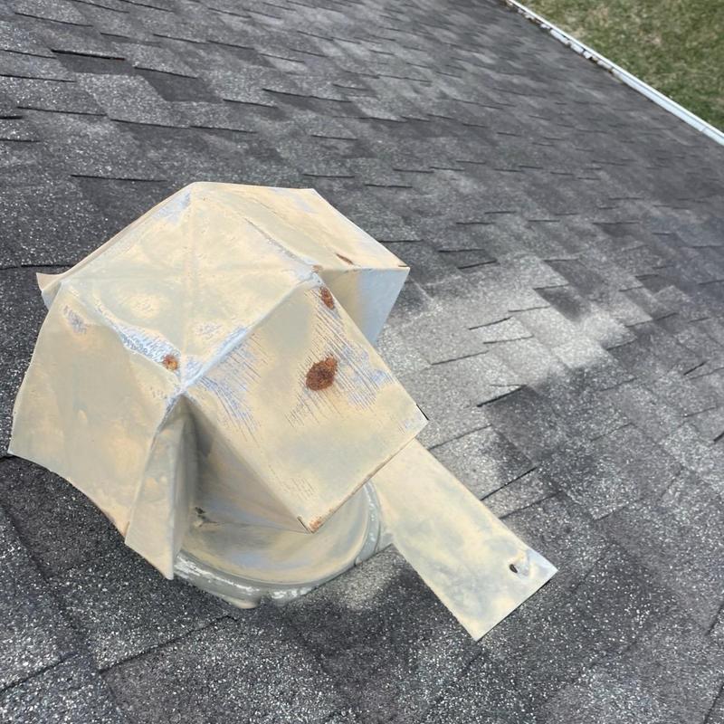 Roof exhaust vent with rust and sealant on shingles
