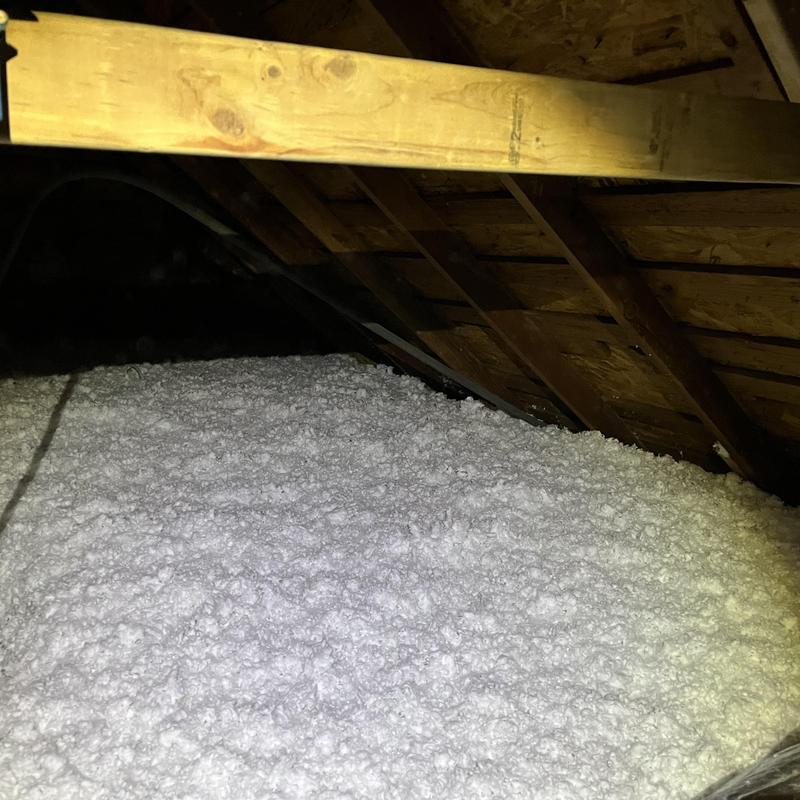 Attic loose-fill insulation installation in wood-framed attic