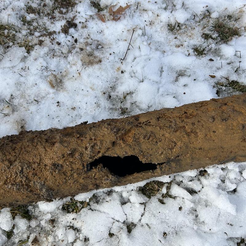 Sewer line with large crack and debris inside pipe