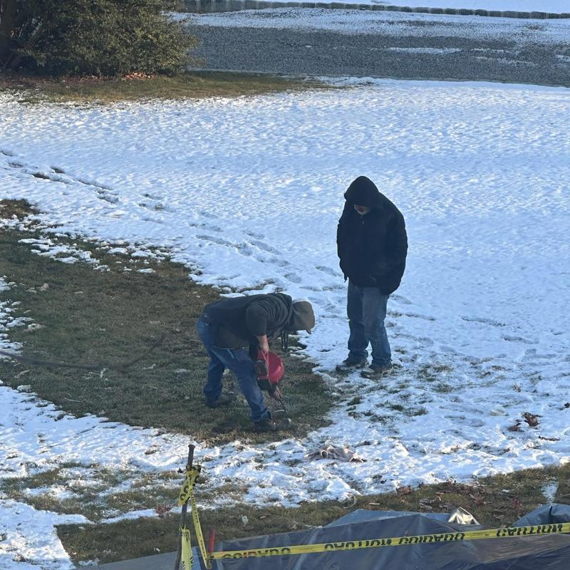 Underground pipe location marking in snowy yard