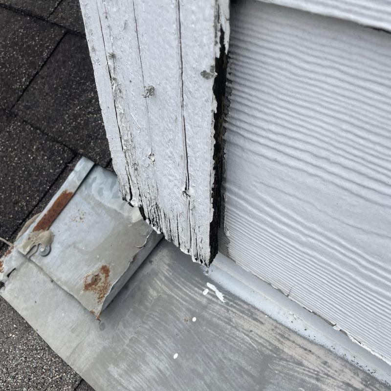 Chimney siding with wood rot and damaged flashing