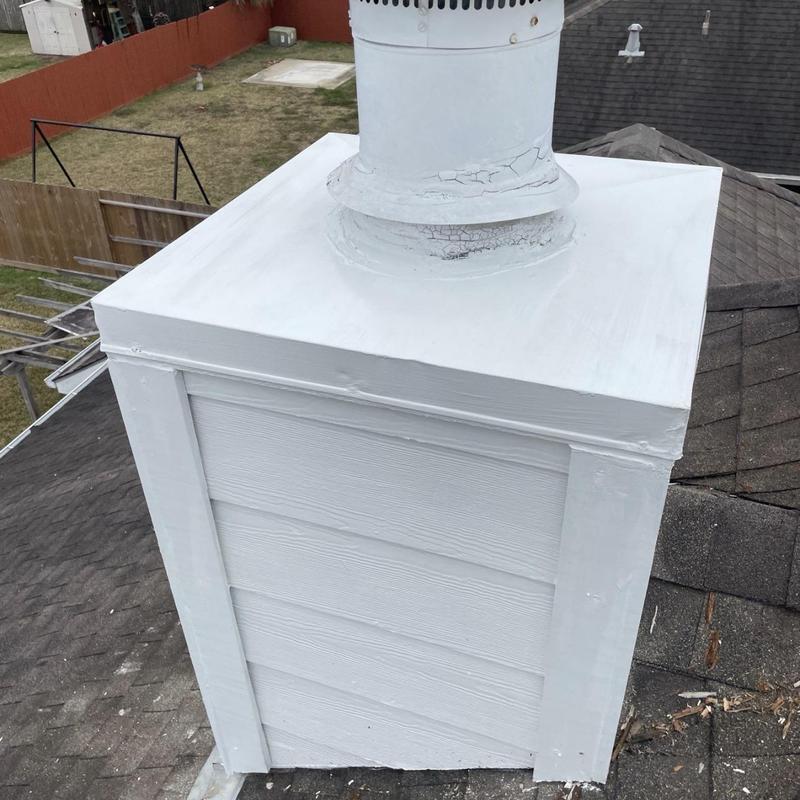 Chimney siding with fresh white paint on roof