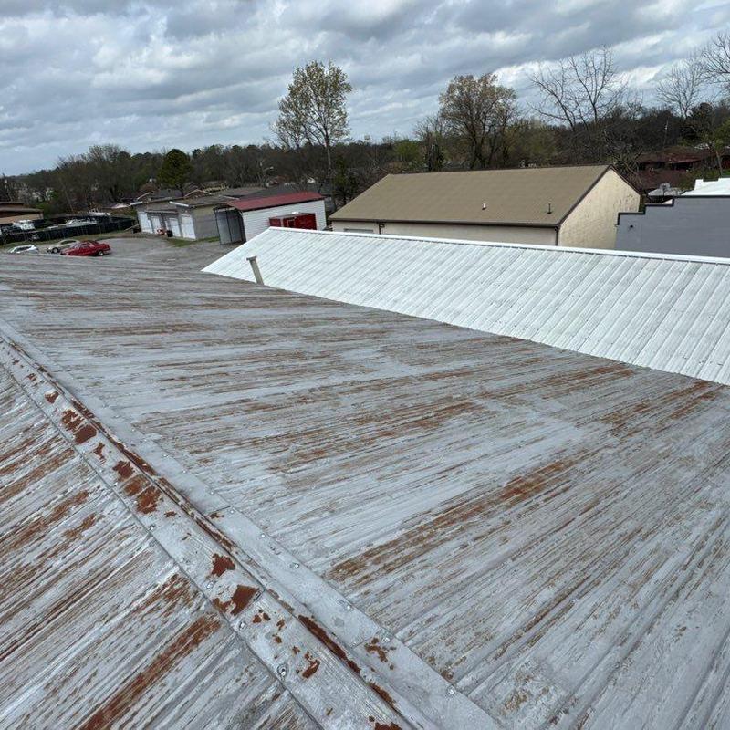 Metal commercial roof with hail damage and rust spots