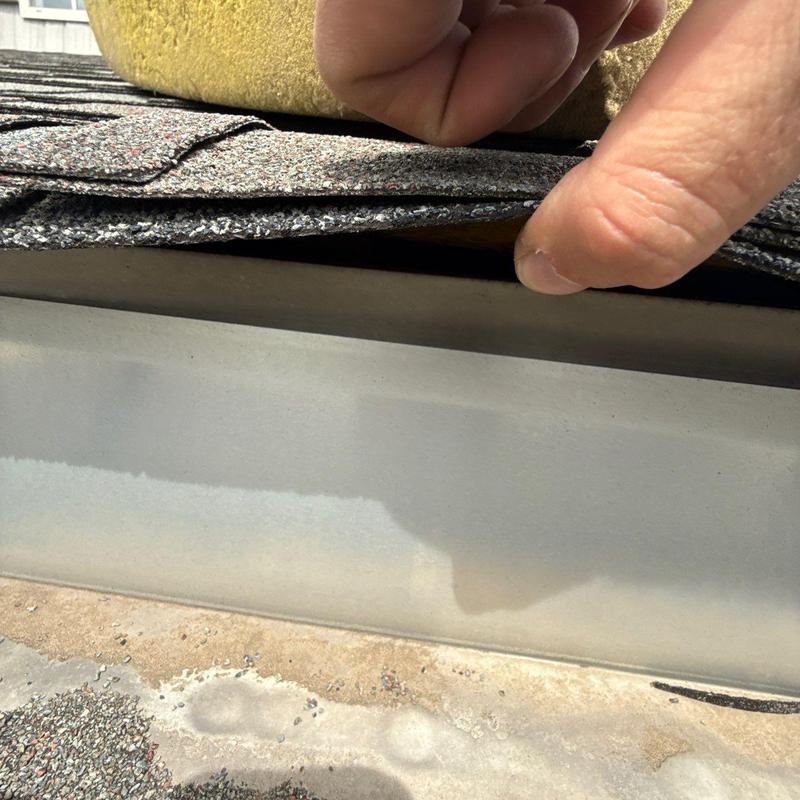 Asphalt shingles lifted for roof flashing inspection