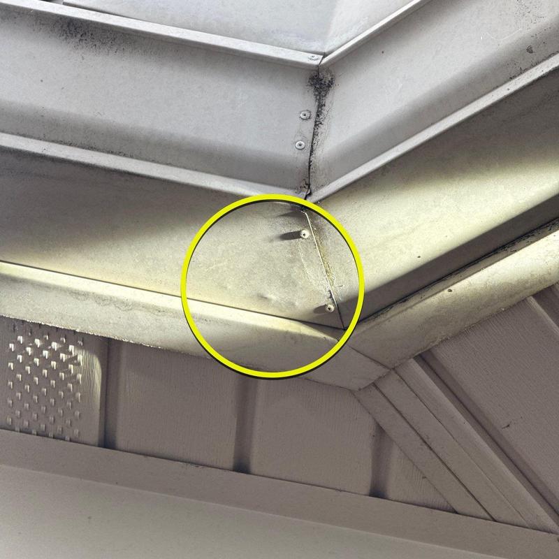 Metal gutter dent with seam and screw detail