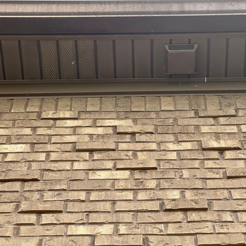 Brick veneer with mortar joint separation under soffit vent