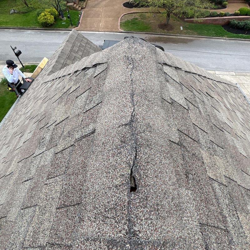 Roof ridge shingles with visible damage and wear