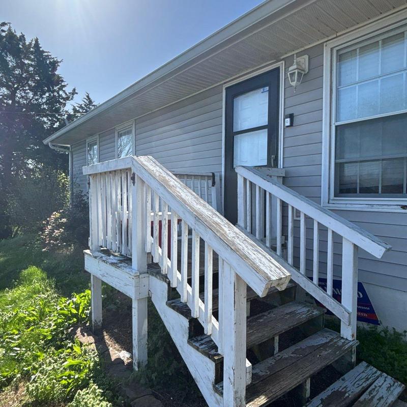 Wooden porch stairs and railing with paint wear