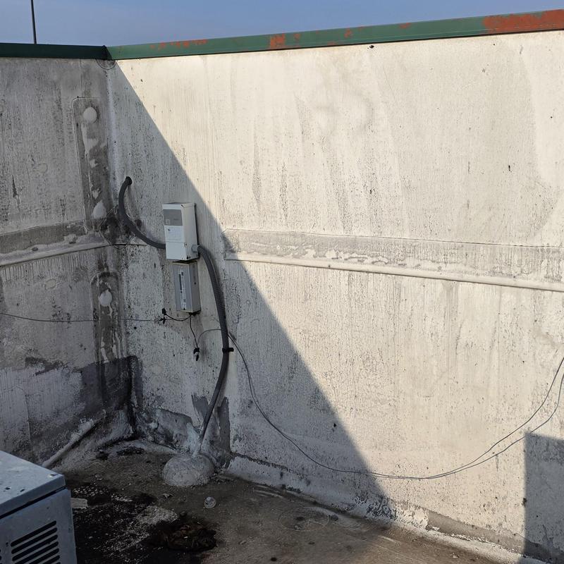 Electrical conduit and panel on rooftop wall after hailstorm