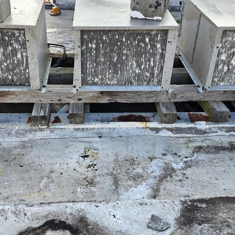 Rooftop HVAC units with weathered wooden supports