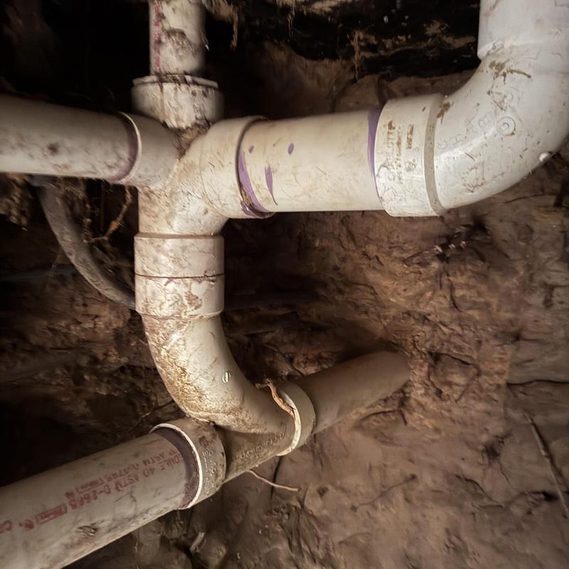 Broken PVC sewer pipe under floor excavation