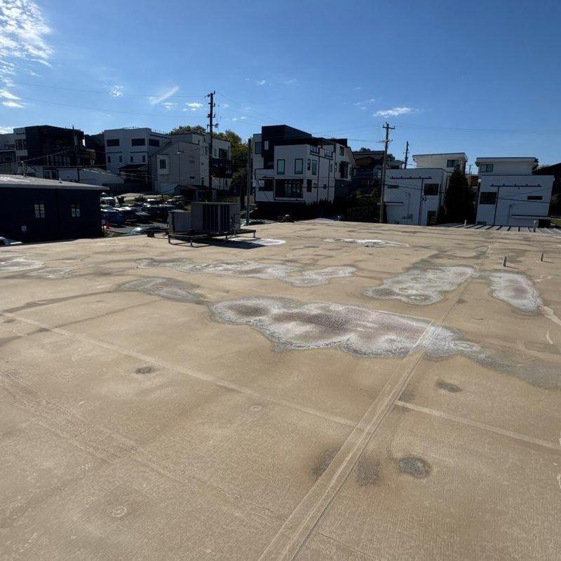 TPO flat roof with wear spots and HVAC unit