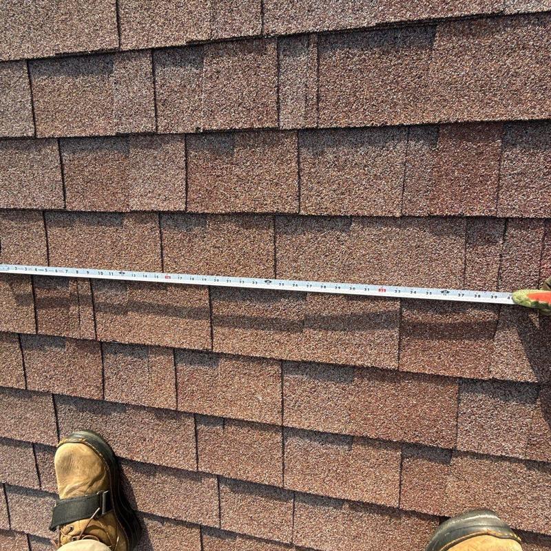 Asphalt shingle roof with measuring tape and boots