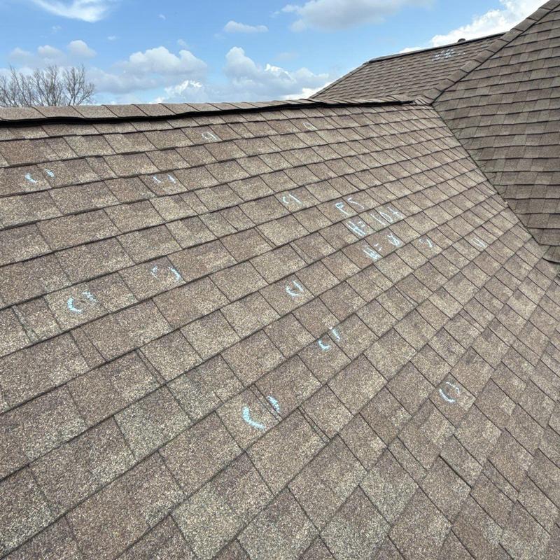 Asphalt shingle roof with hail damage marked for repair