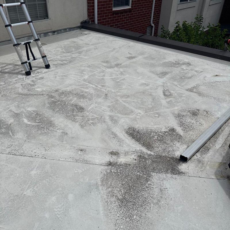 TPO commercial flat roof surface with ladder and debris