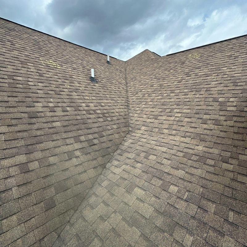 Asphalt shingles roof valley with hail damage marks