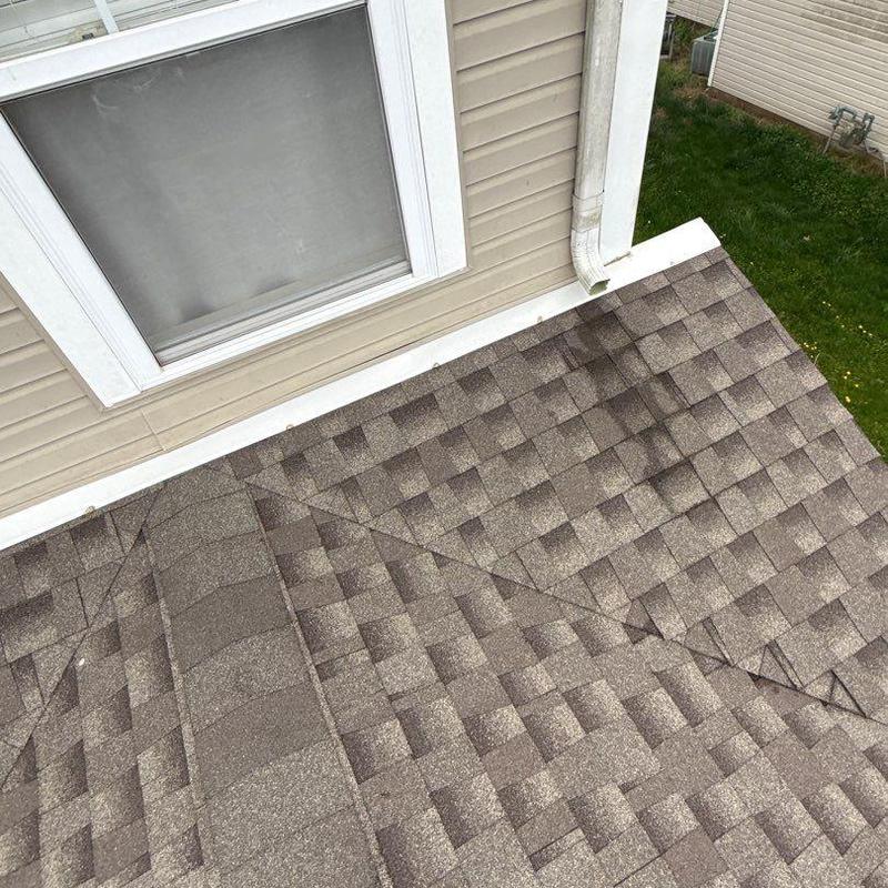 Asphalt shingles with visible hail damage on roof