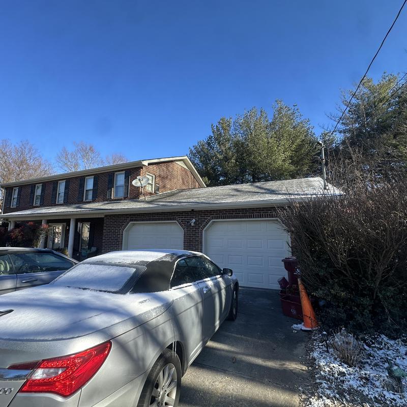 Metal roof on residential home with cars in driveway