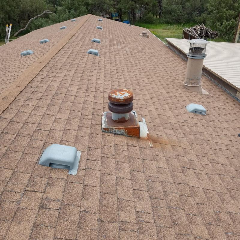 Asphalt shingle roof with vent pipes and rust damage Asphalt shingle roof with vent pipes and rust damage