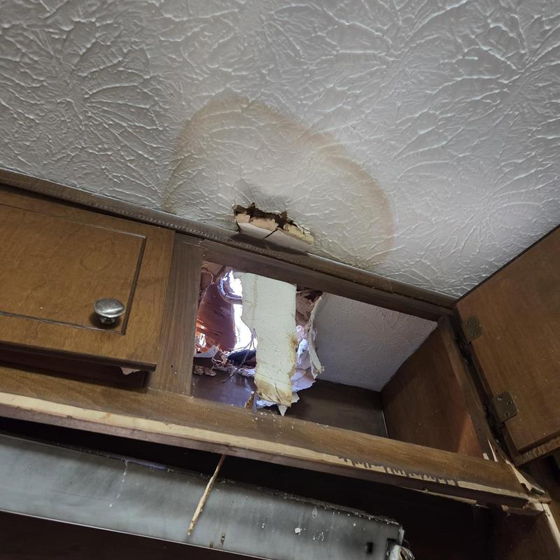 Ceiling drywall with hole and water stain damage