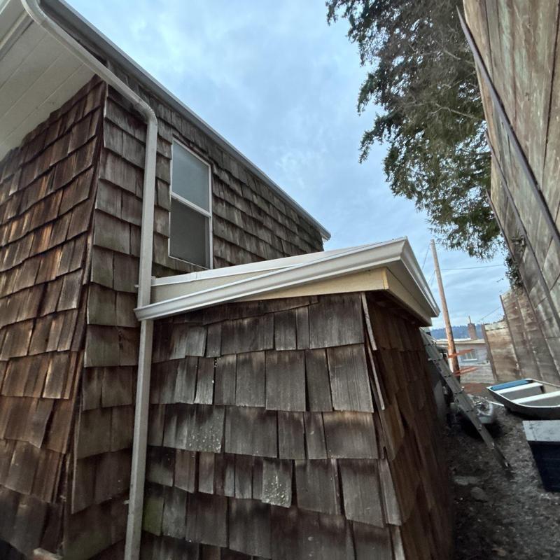 Flat roof with new white gutters and flashings installed