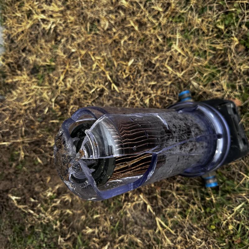 Water filter housing with visible crack and dirt