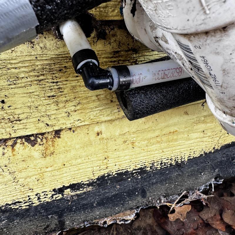 PVC pipe section with elbow connection on exterior wall