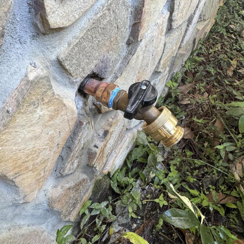 Outdoor hose bib installation on stone wall