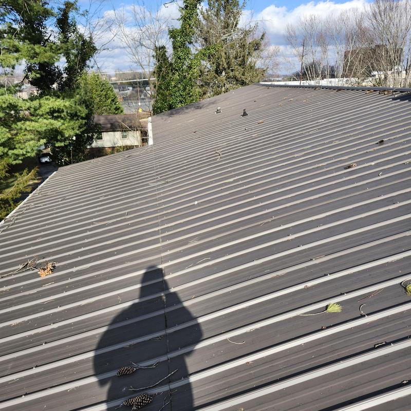 Metal roof with debris and minor dents outdoors