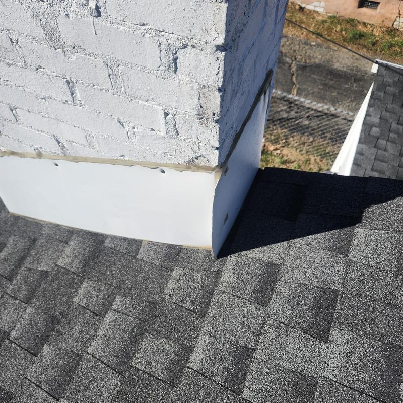Chimney base flashing and pipe boot on asphalt roof