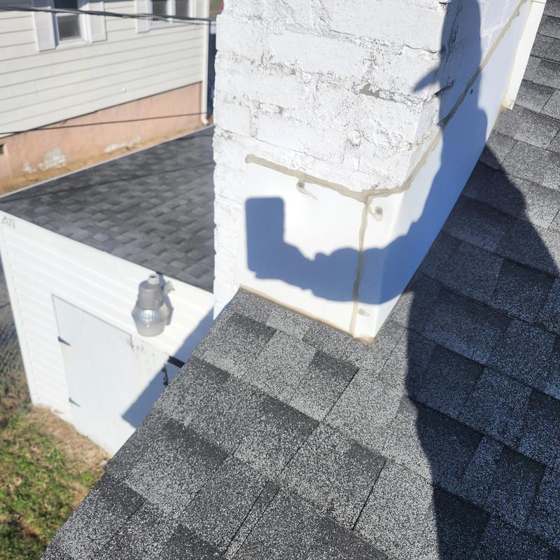 Chimney reflashing and pipe boot on shingled roof