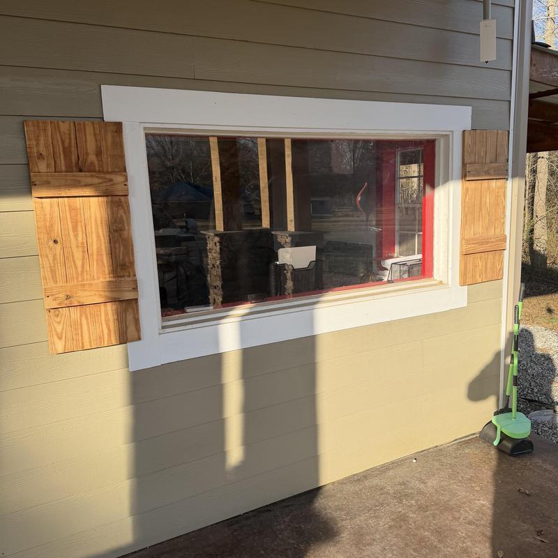 Window with newly installed wooden shutters outdoors Window with newly installed wooden shutters outdoors