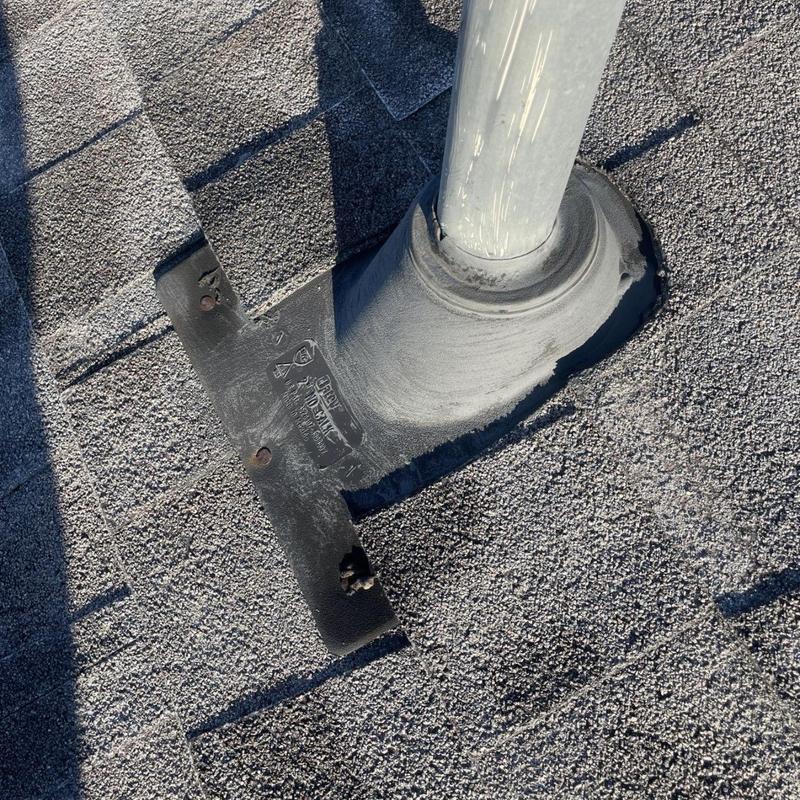 Plumbing pipe boot flashing on asphalt roof shingles