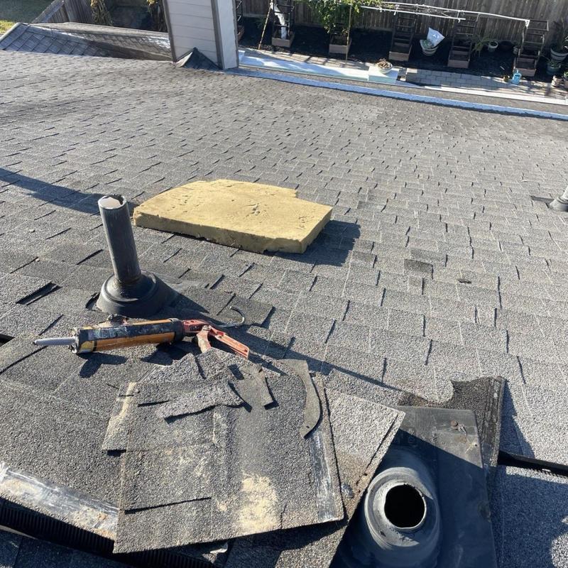 Plumbing pipe boot with removed shingles on roof