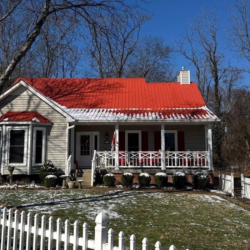 Metal roof with partial snow coverage on house