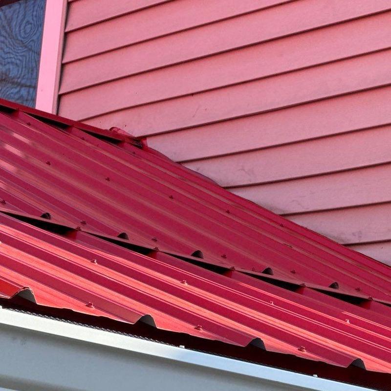 Metal roofing panels with fastener inspection near siding