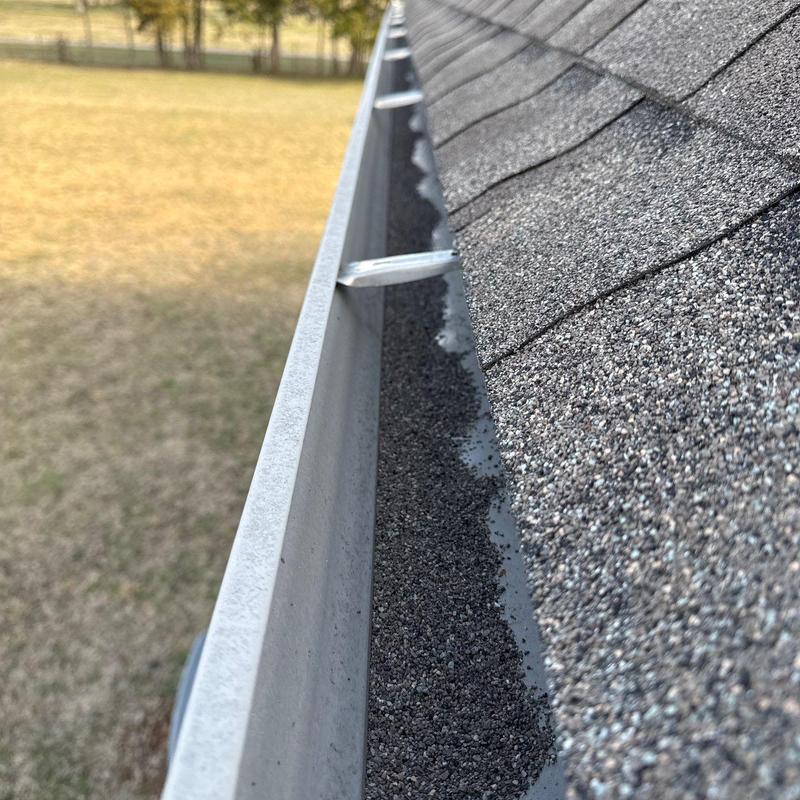 Roof shingles granule loss along gutter edge close-up