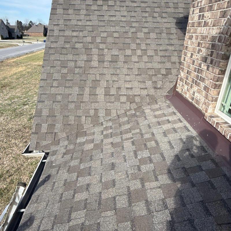 Asphalt shingle roof near brick wall with flashing