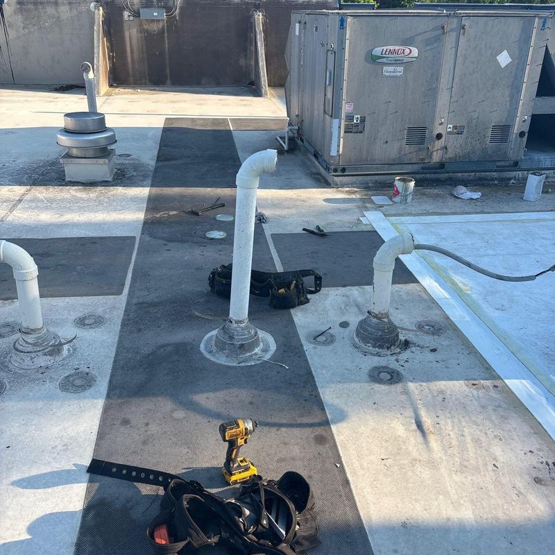 Commercial roofing ventilation pipes and HVAC unit on roof