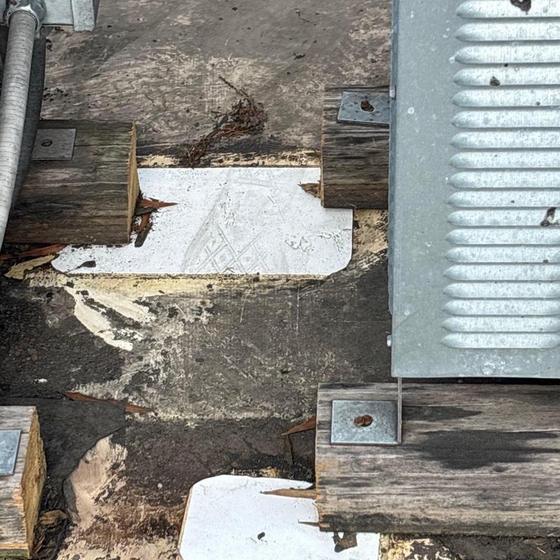 Commercial roof flashing with hail damage and wooden supports