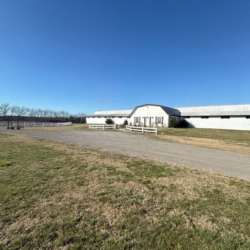 Metal roof inspection on white barn building