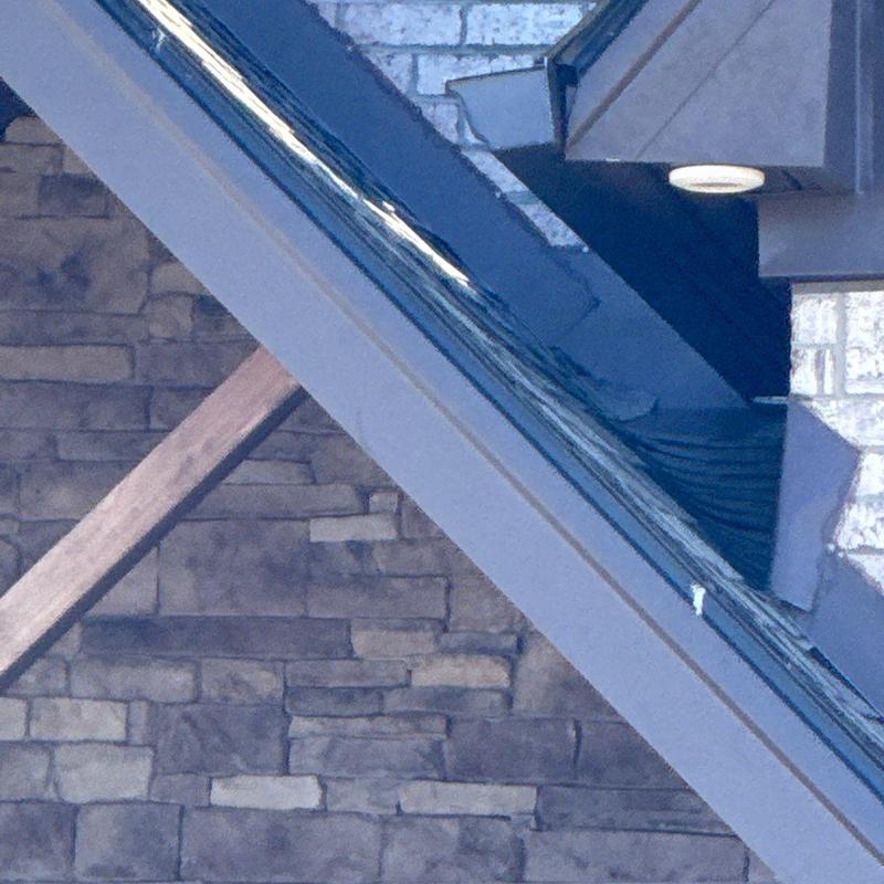 Roof shingle hail damage near gutter and roof transitions