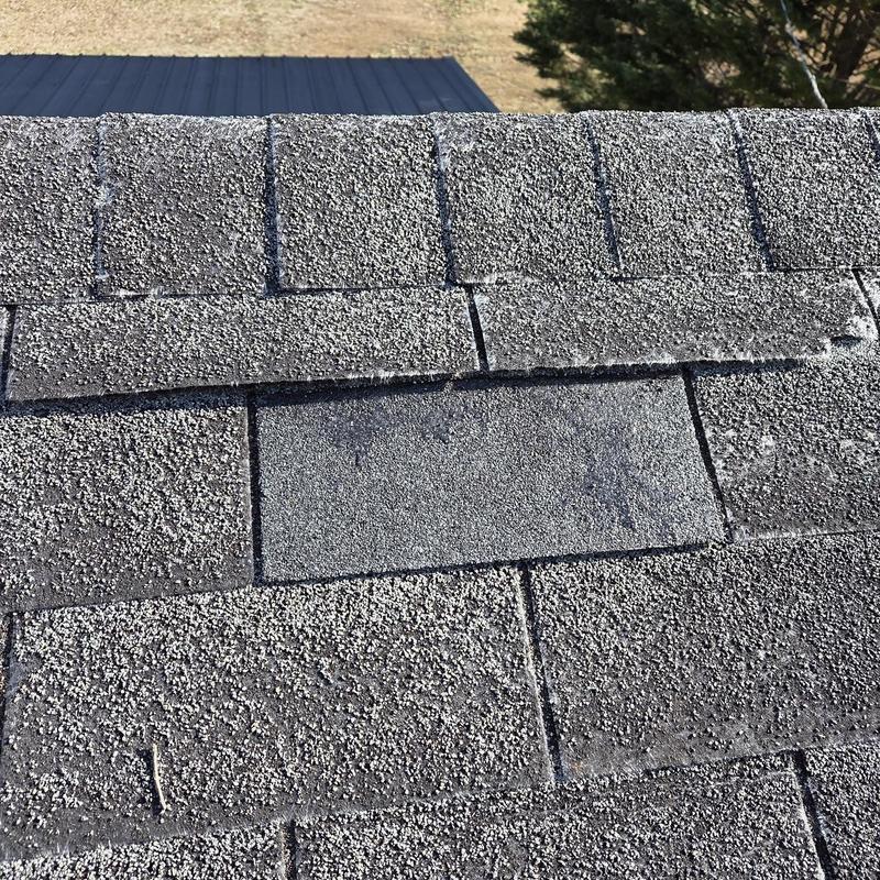 Roof shingles with replaced and repaired sections close-up