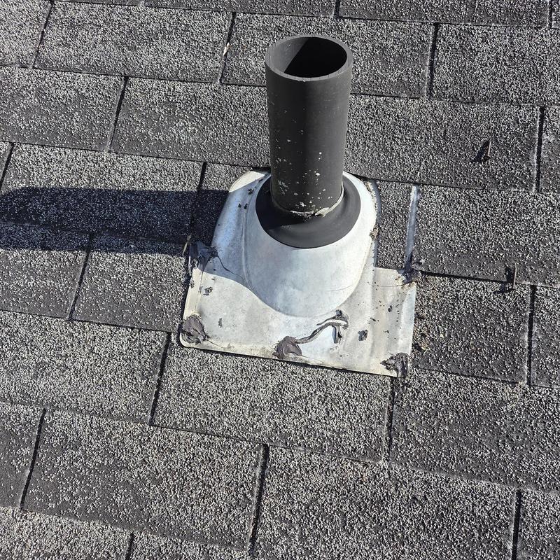 Roof vent flashing with replaced shingles and caulking